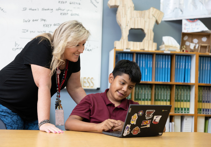 Teacher with student at laptop